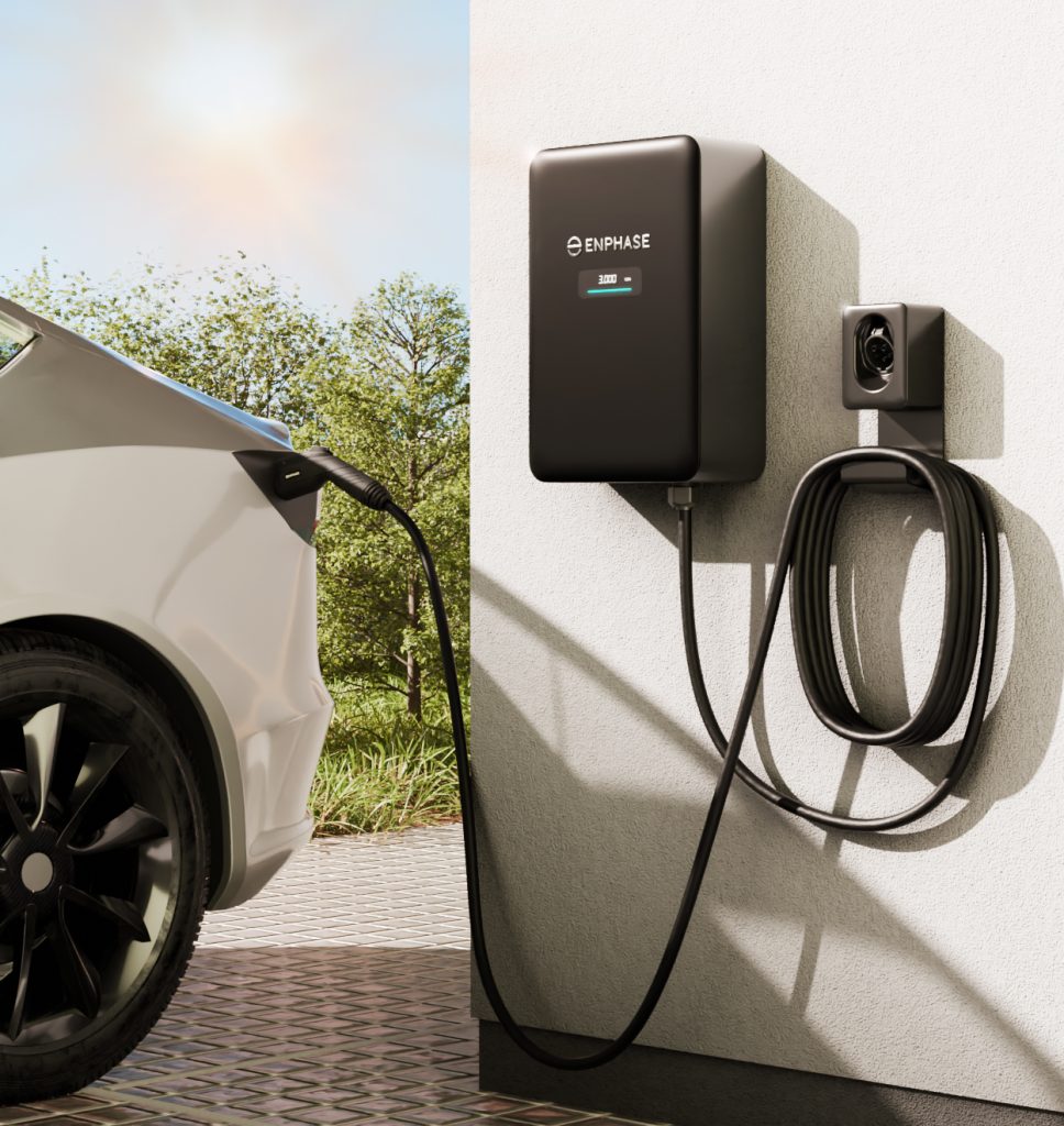 Borne de recharge murale Enphase installée sur la façade d'une maison, reliée à un véhicule électrique.